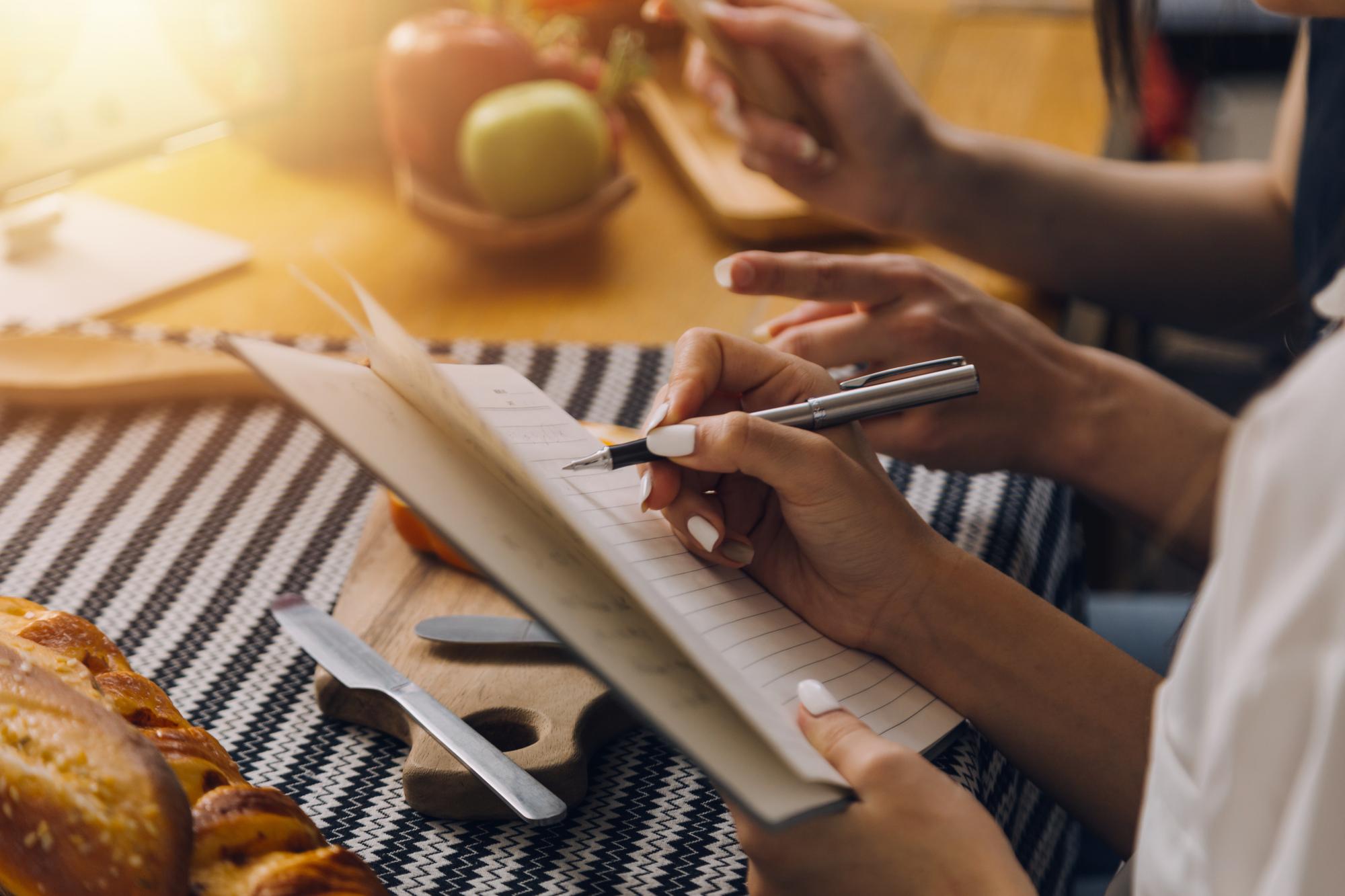 Chef writing weekly recipe plan on kraft paper
