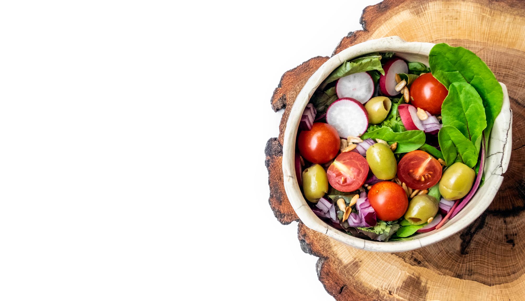 Bright bowl of seasonal salad on wooden table
